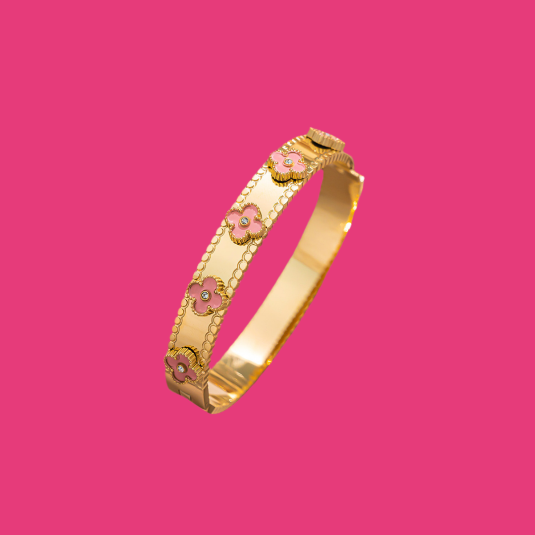 Gold-tone bangle with pink clover motifs from Lucky Bangles, featuring raised scallop trim.