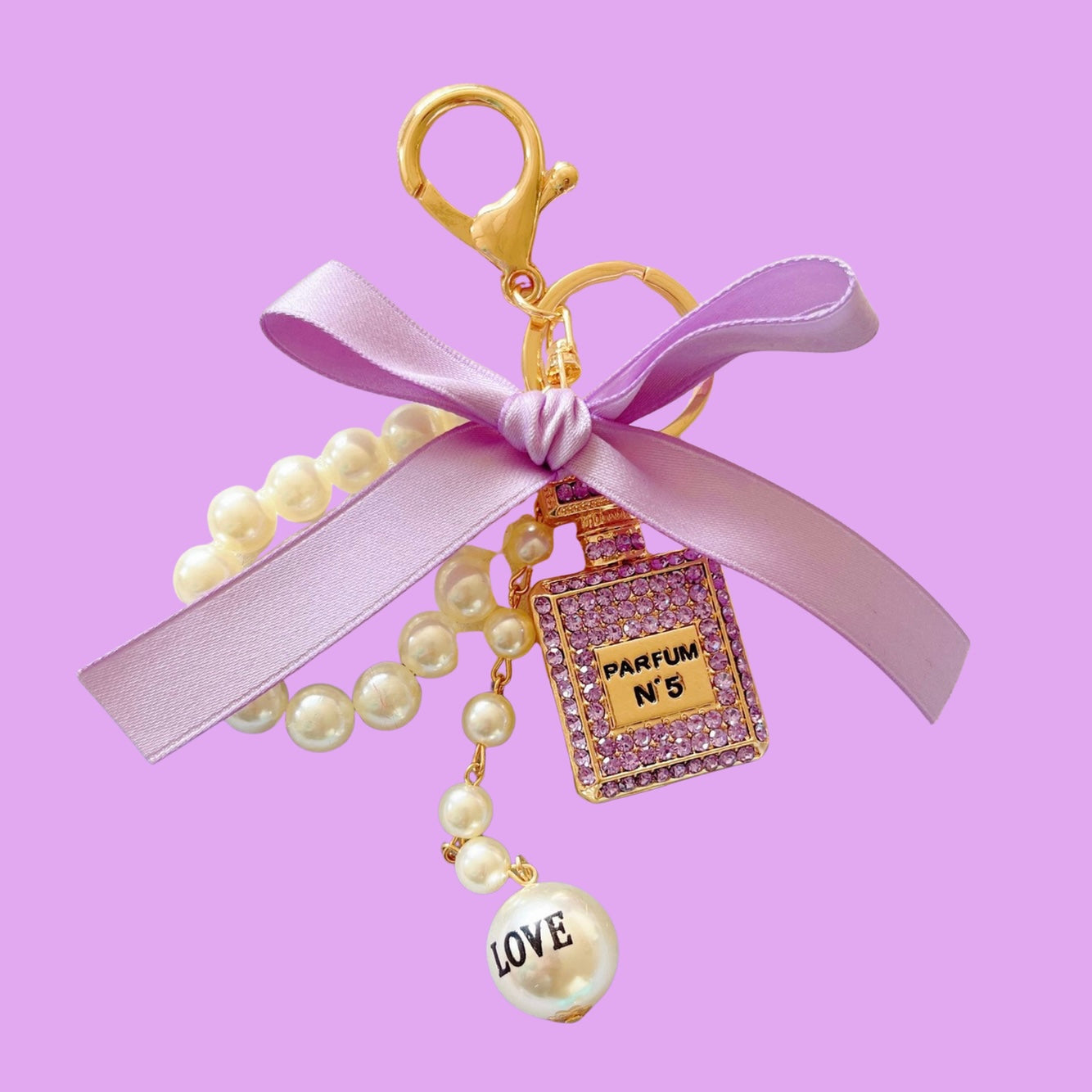 Crystal bag charm in a parfum shape with pearls by an unknown vendor, featuring a lavender bow and "LOVE" detail.