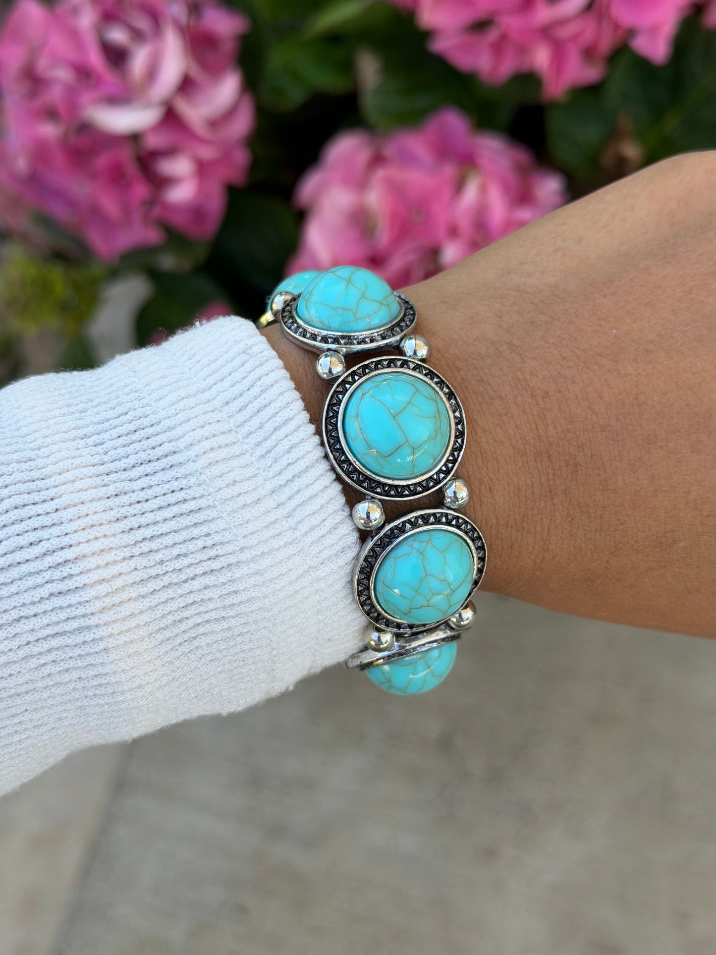 Chunky Boho Bracelet with five oval crackled turquoise stones in ornate silver-tone settings, worn on a wrist with a white sleeve.