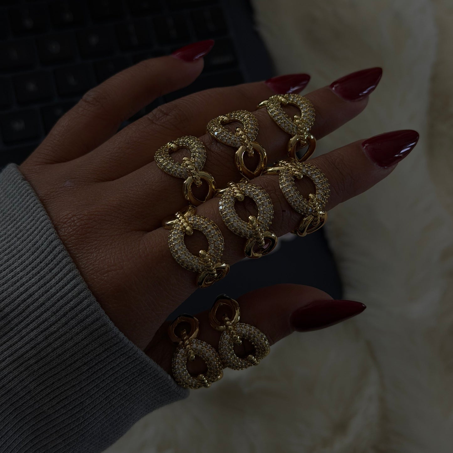 Gold adjustable statement ring featuring a pavé-set circular design, shown stacked and worn on hand.