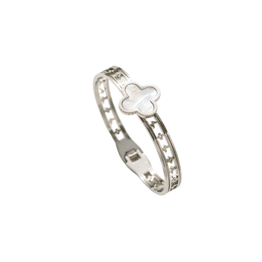 Silver bangle with a white mother-of-pearl four-leaf clover charm and star cut-outs.