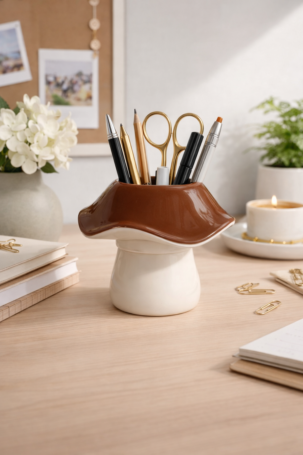 Two-tone brown and cream mushroom pen holder holding pens and scissors on a light wooden desk.