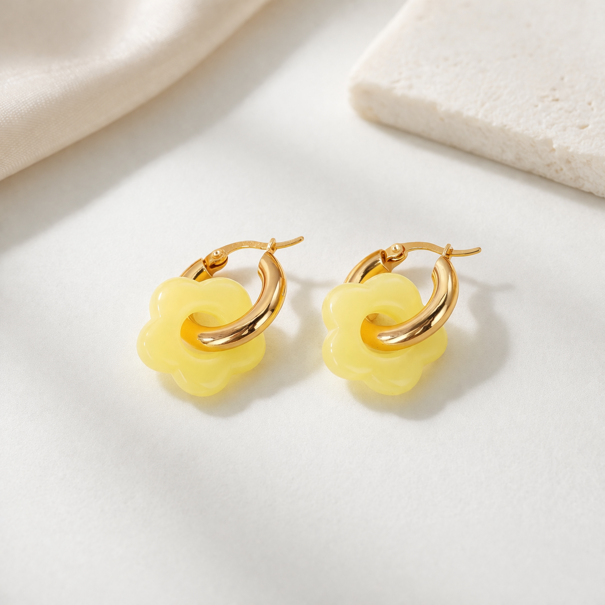 Glossy yellow flower Bloom Hoops Earrings with gold-toned hoops, displayed side-by-side on a white surface.