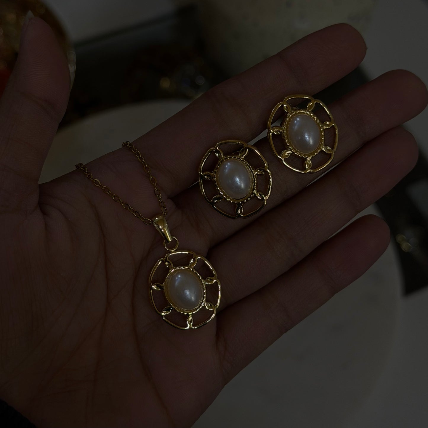 Gold jewelry with pearl-like stones on a hand