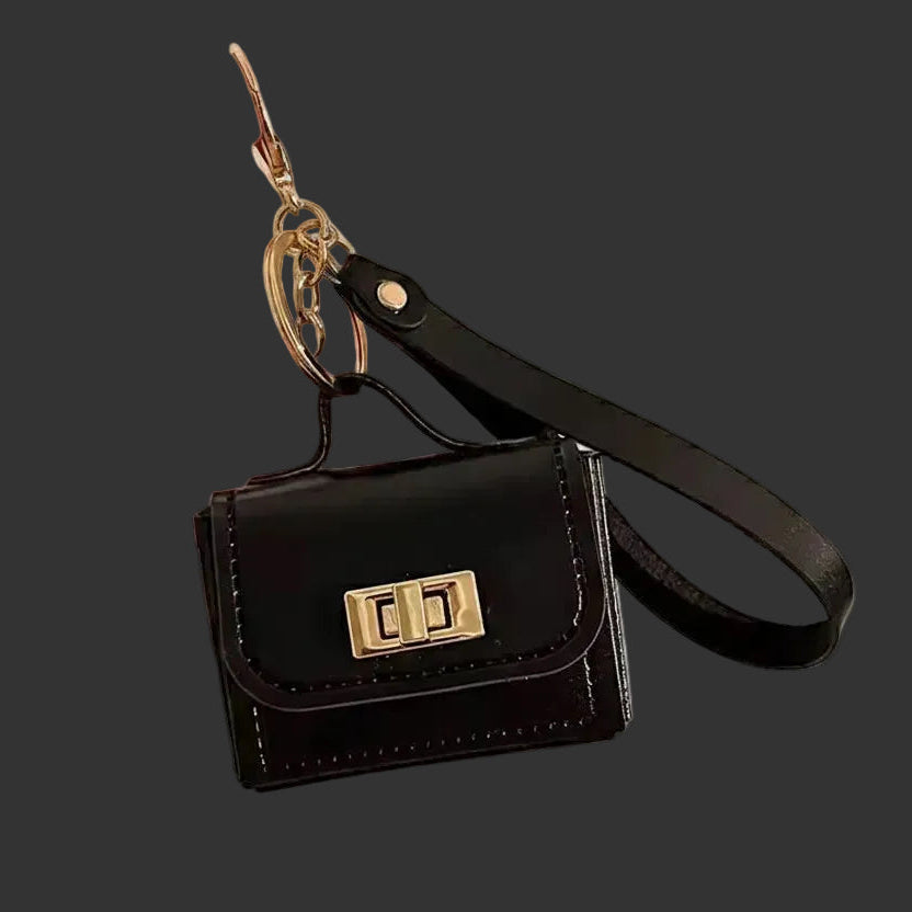Mini leather purse bag charm with gold hardware and wrist strap.