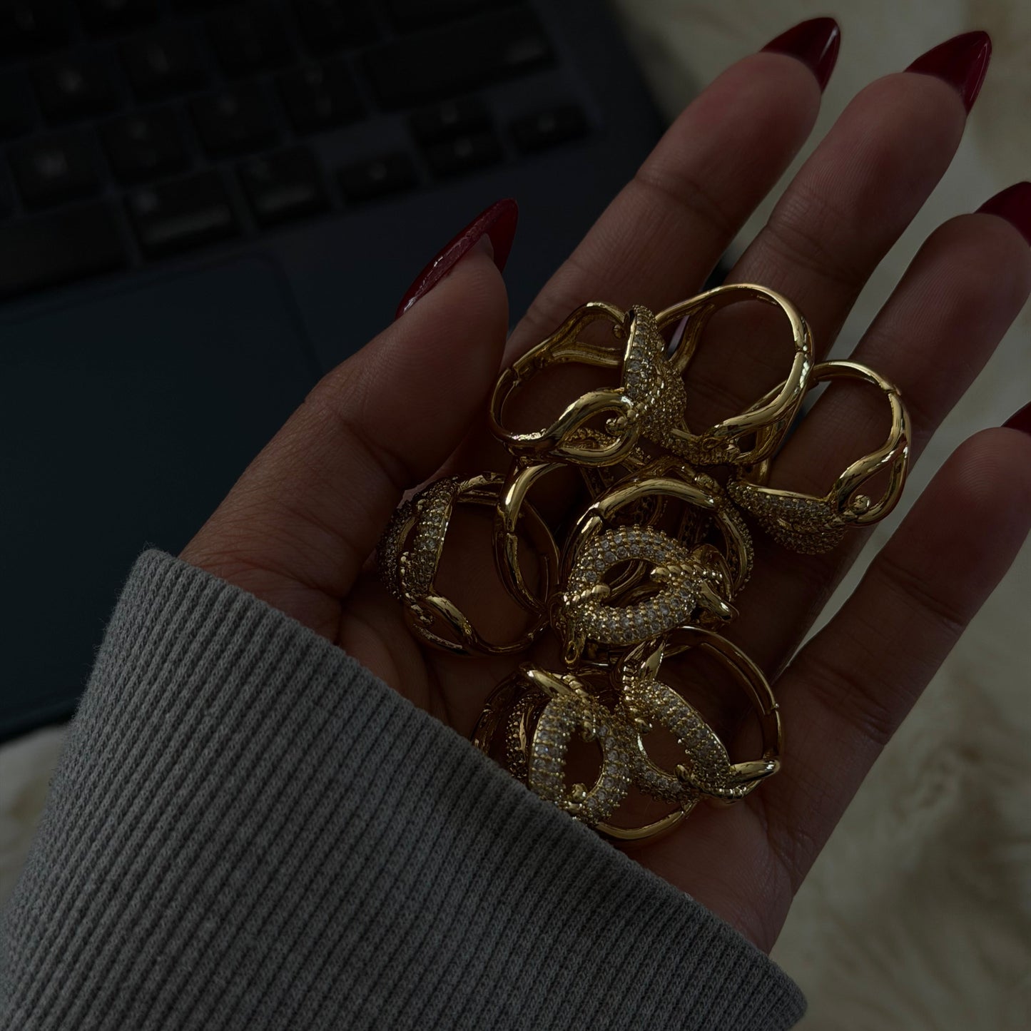 Hand holding gold rings with a blurred background