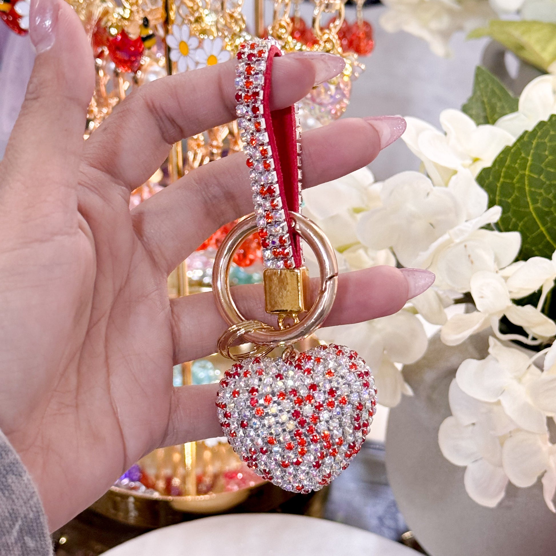 Rhinestone heart bag charm from Valentine's Day Collection, featuring red and clear crystals with a gold ring and red strap.