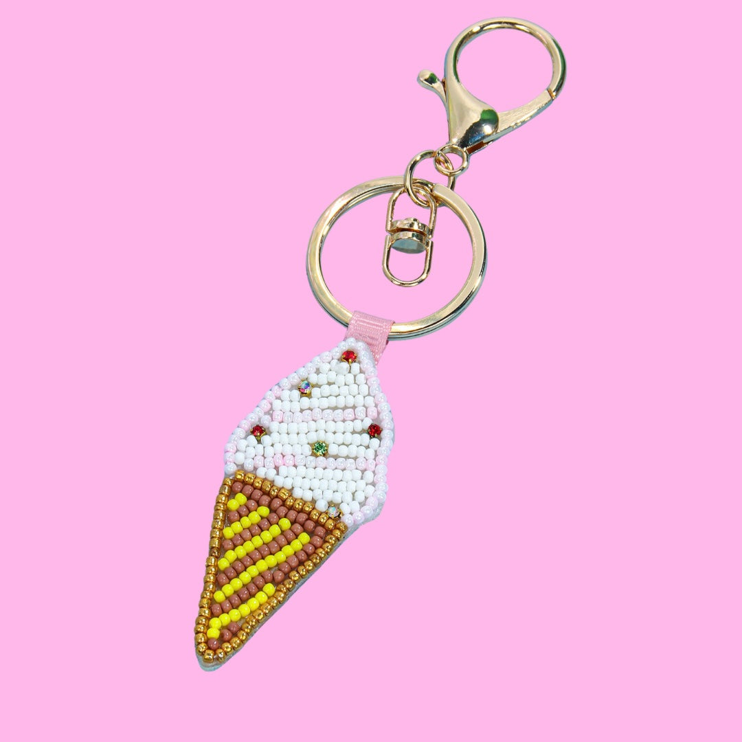 Beaded ice cream cone bag charm with white 'ice cream' and colorful rhinestones, brown and yellow striped cone, and gold-tone key ring.