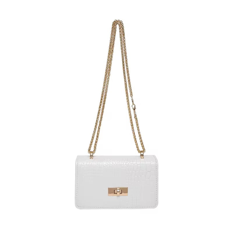 White shoulder bag by Bella with a gold chain strap and faux snakeskin texture.