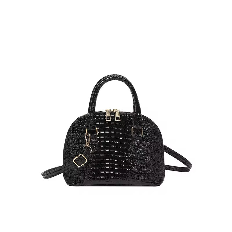 Black dome crossbody bag with a crocodile pattern texture.