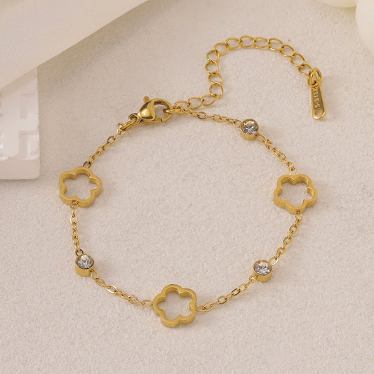 Gold-toned chain bracelet with open clover charms, clear cubic zirconia stones, and an 'S-STEEL' tag.
