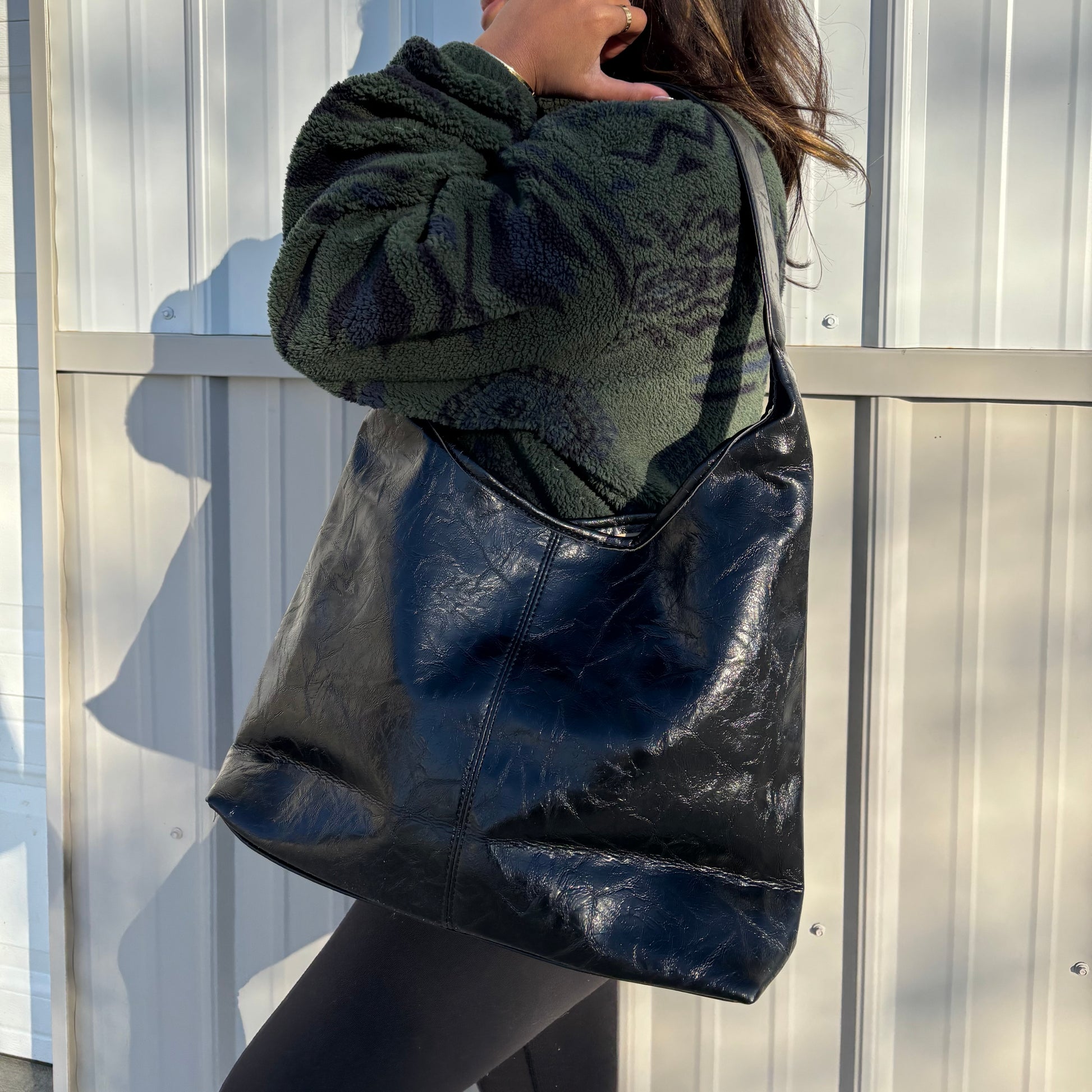 Black leather tote bag from A New Day, styled with a cozy green patterned fleece and leggings.