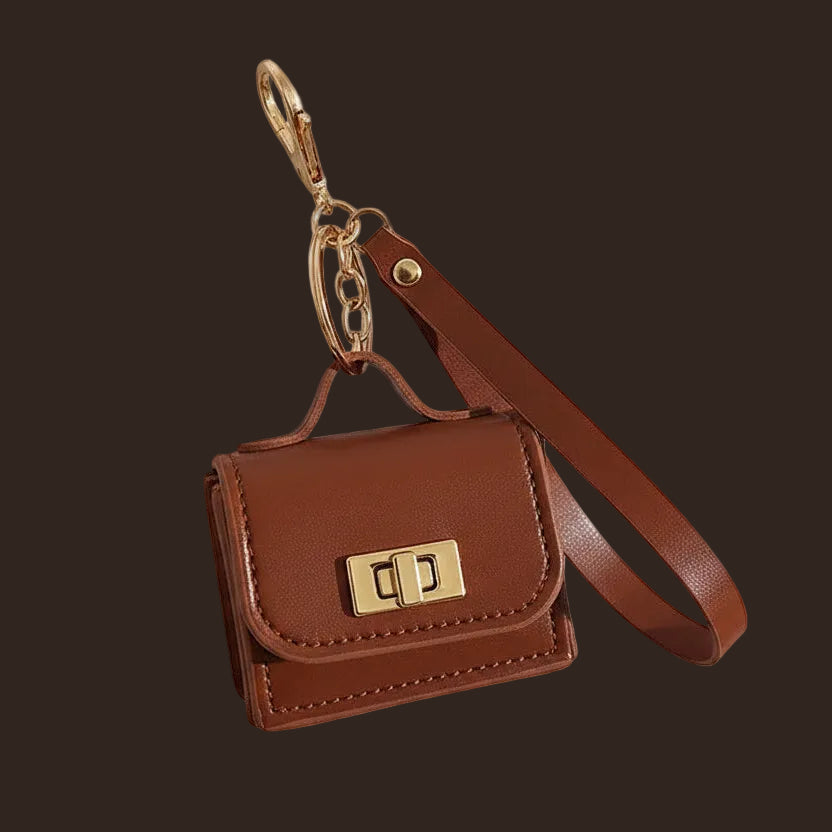 Mini leather purse bag charm with gold hardware and wrist strap.