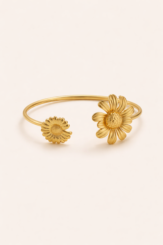 Gold flower-shaped rings on a light beige background