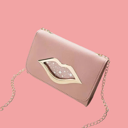 Pink clutch-style handbag with silver chain strap and lip-shaped metal accent, displayed on a Pink background.