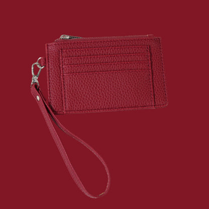 Red slim wristlet card holder with clear ID pocket, with a pebbled texture.