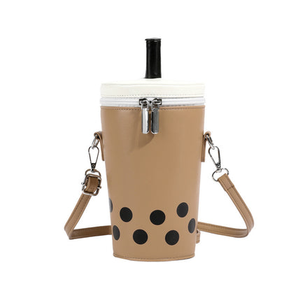 Tan boba tea crossbody bag with white top, black straw, and black boba dots, featuring a top zipper and adjustable strap.