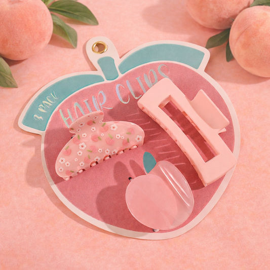 Peach-themed hair clip set featuring three pink claw clips in different shapes displayed on a peach-shaped backing card with a soft peach background.