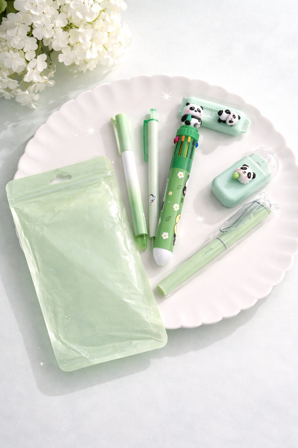 Light green desk set featuring panda-themed pens, correction tape, highlighter, and a pouch, neatly arranged on a white plate.