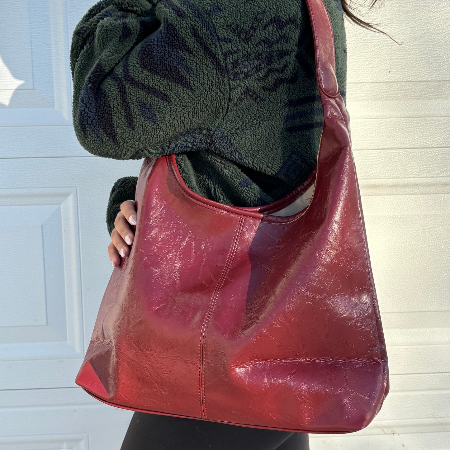 Red leather hobo bag from The Downtown Tote Bag, styled with a dark green fleece jacket.