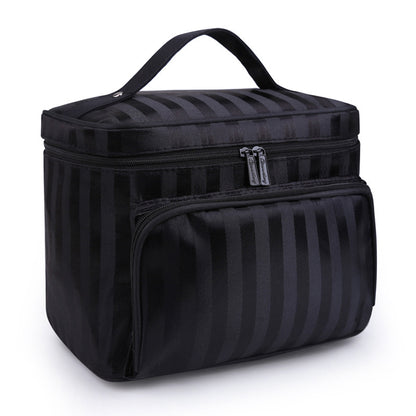 Black makeup bag by Bella with subtle vertical stripes, a top handle, and two zippered compartments.