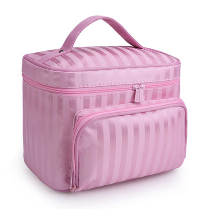 Pink vertical striped makeup bag by Bella with a top handle and a zippered front pocket.