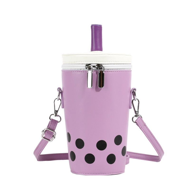 Purple boba tea crossbody bag with black tapioca dots, white lid, purple straw, and silver zippers, shown front view.