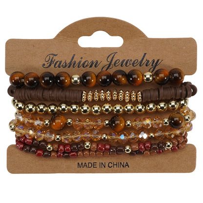 Bohemian style layered bracelets with brown, gold, and amber faceted beads, on a cardboard hanger.