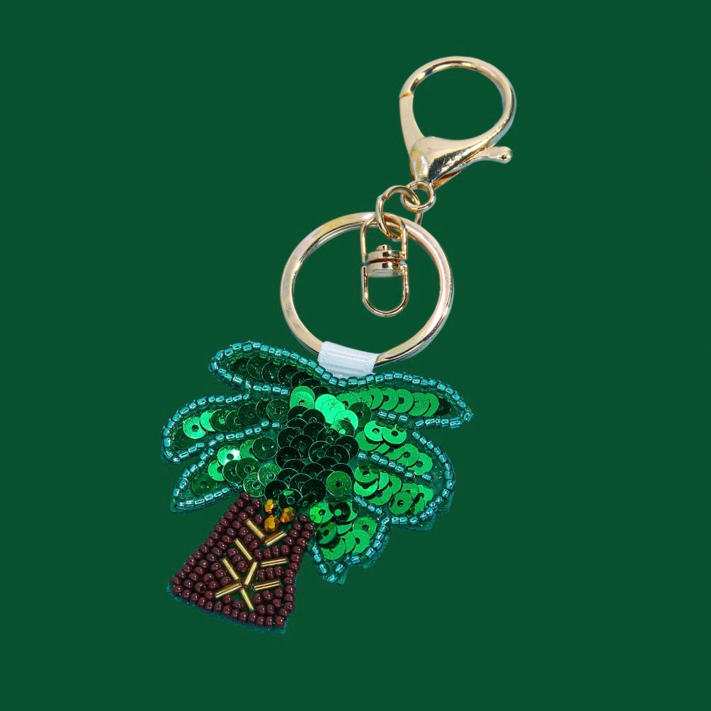 Green and brown palm tree beaded bag charm with sequins and a gold-tone clasp.