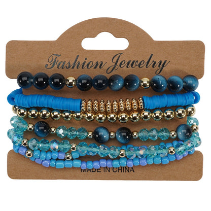 Bohemian style layered bracelets in shades of blue and gold beads on a brown display card.