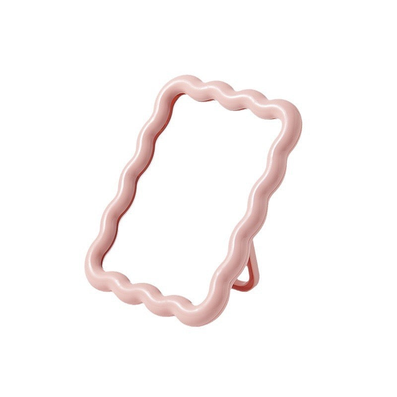 Pink ripple frame mirror standing at an angle.