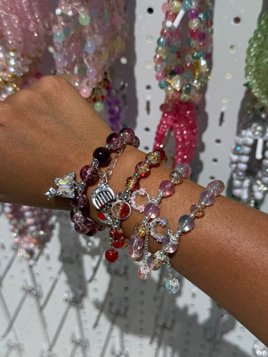 Ethereal Lucky Charm Beaded Bracelet with multicolor beads and silver charms, stacked on a person's wrist.