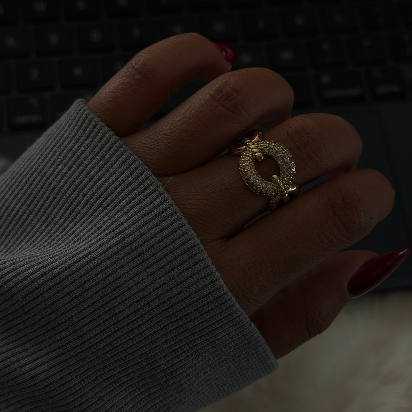 Close-up of a hand wearing a gold ring with a blurred background