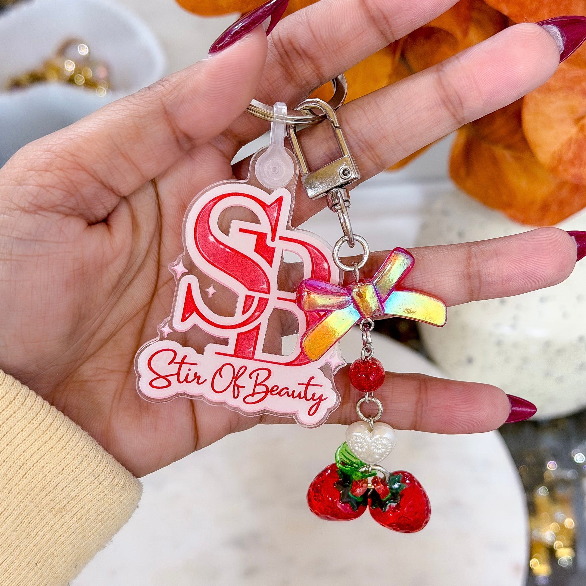 Strawberry kiss charm by Stir of Beauty with a rainbow bow, heart, red beads, and glossy strawberry pendants.