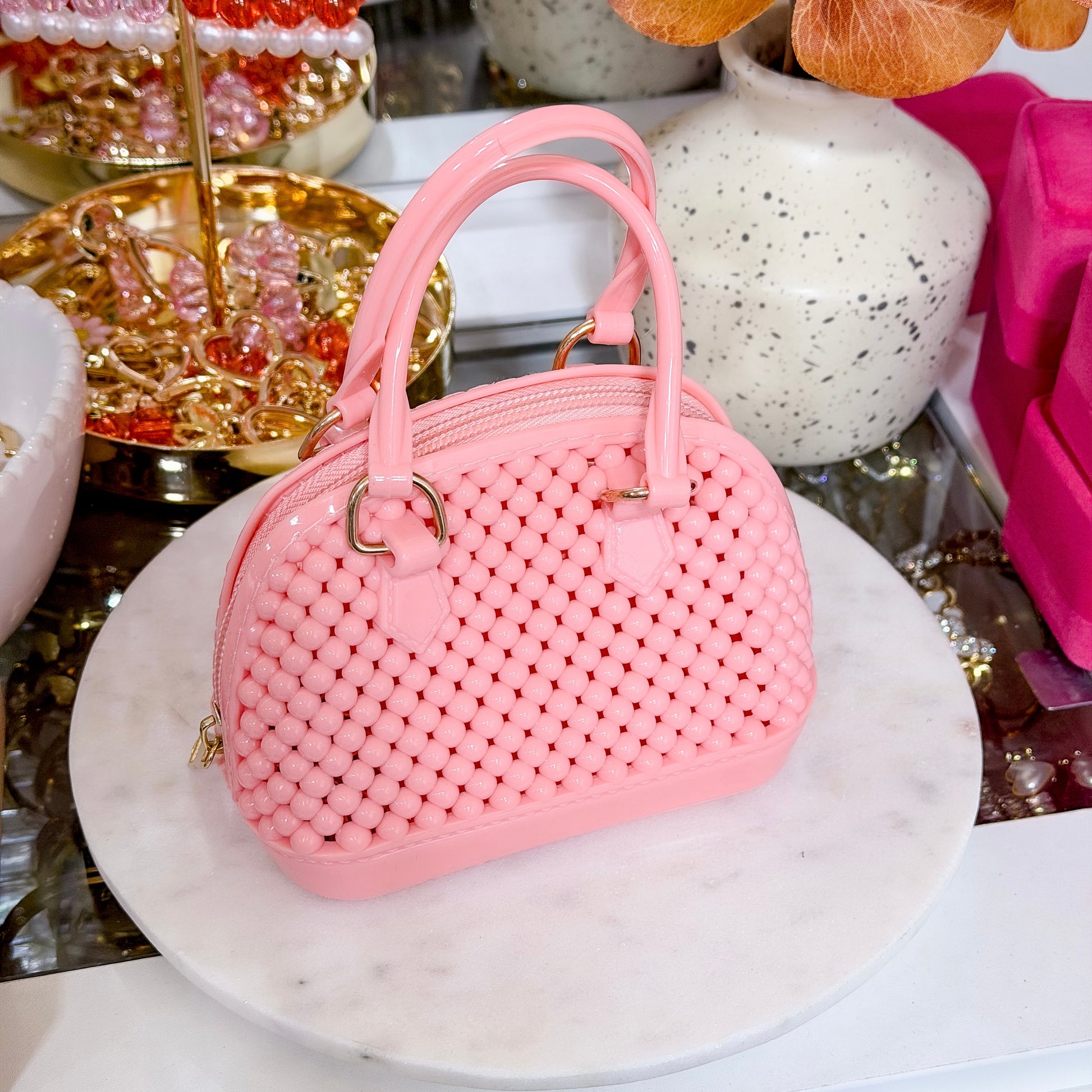 Pink beaded dome chain bag with gold-tone hardware and a textured design.