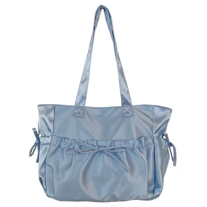 Light blue satin tote bag with bow detail and shoulder straps.