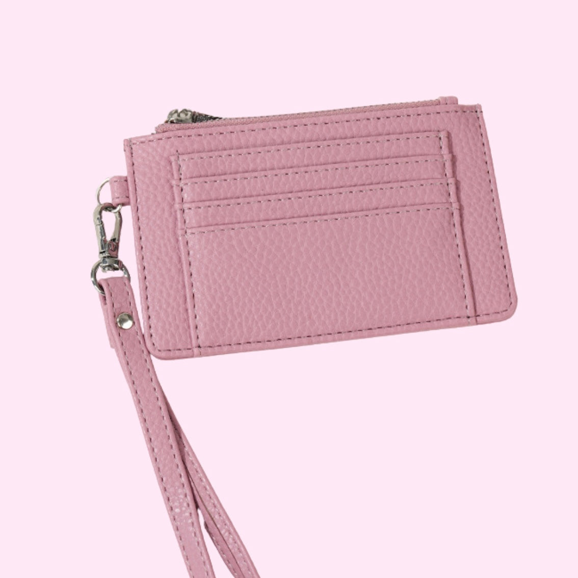 Pink wristlet card holder with clear ID pocket, with silver-tone hardware and textured leather.