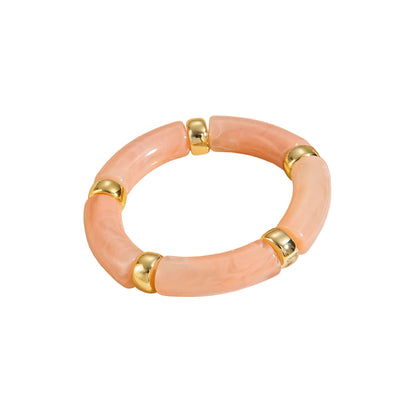 Peachy-pink marbled stretch bracelet with smooth, tube-shaped segments separated by small gold beads.