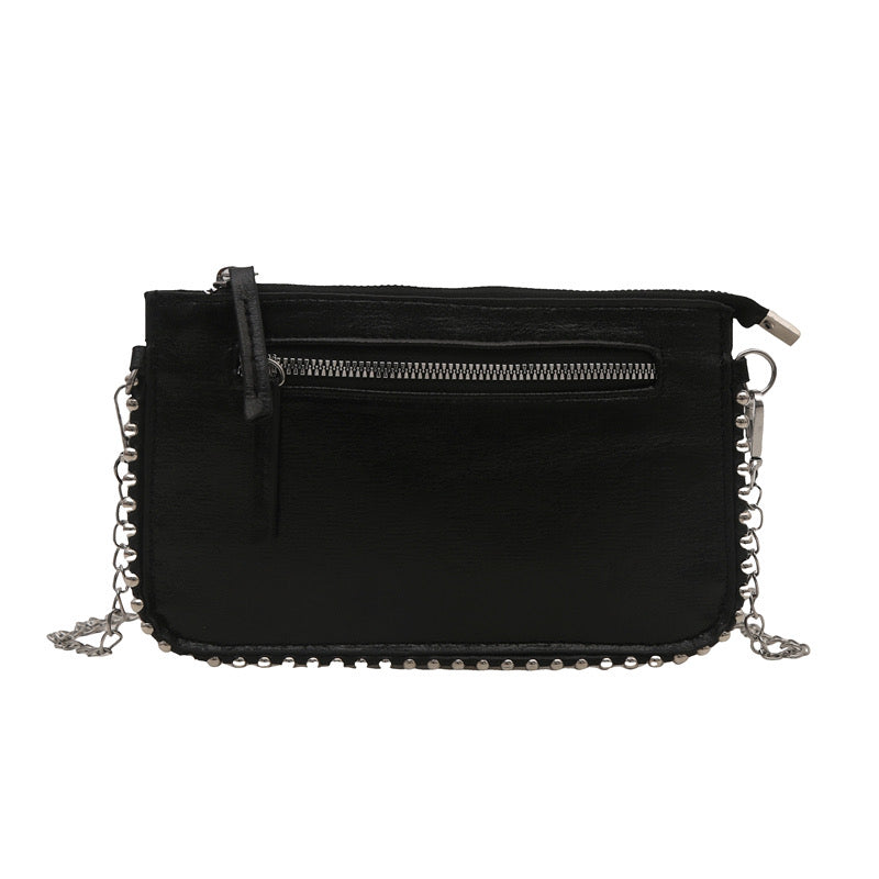 Black mini chain bag by an unknown vendor, featuring a front zipper pocket and studded edges.