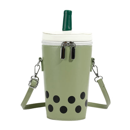 Green boba tea crossbody bag with a white lid, green straw, double silver zippers, and black polka dots, featuring an adjustable strap.