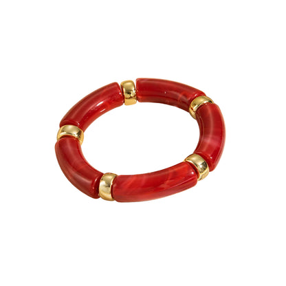 Red and gold segmented bracelet with curved, swirled red sections and smooth gold spacers.