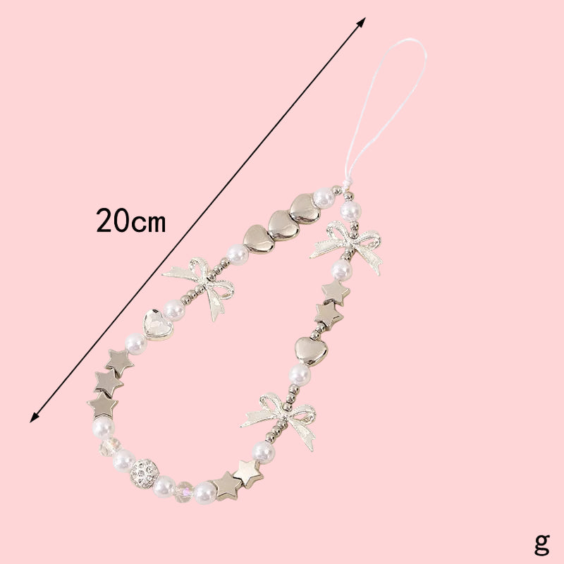 Coquette theme phone charm with white pearls, silver hearts, stars, and bows, measuring 20cm long.