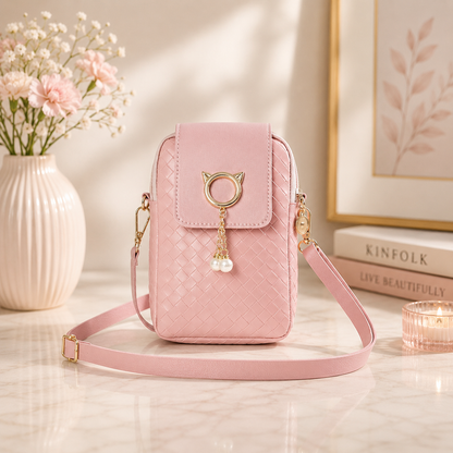 Pink woven phone crossbody pouch featuring a gold cat ring and pearl charm.
