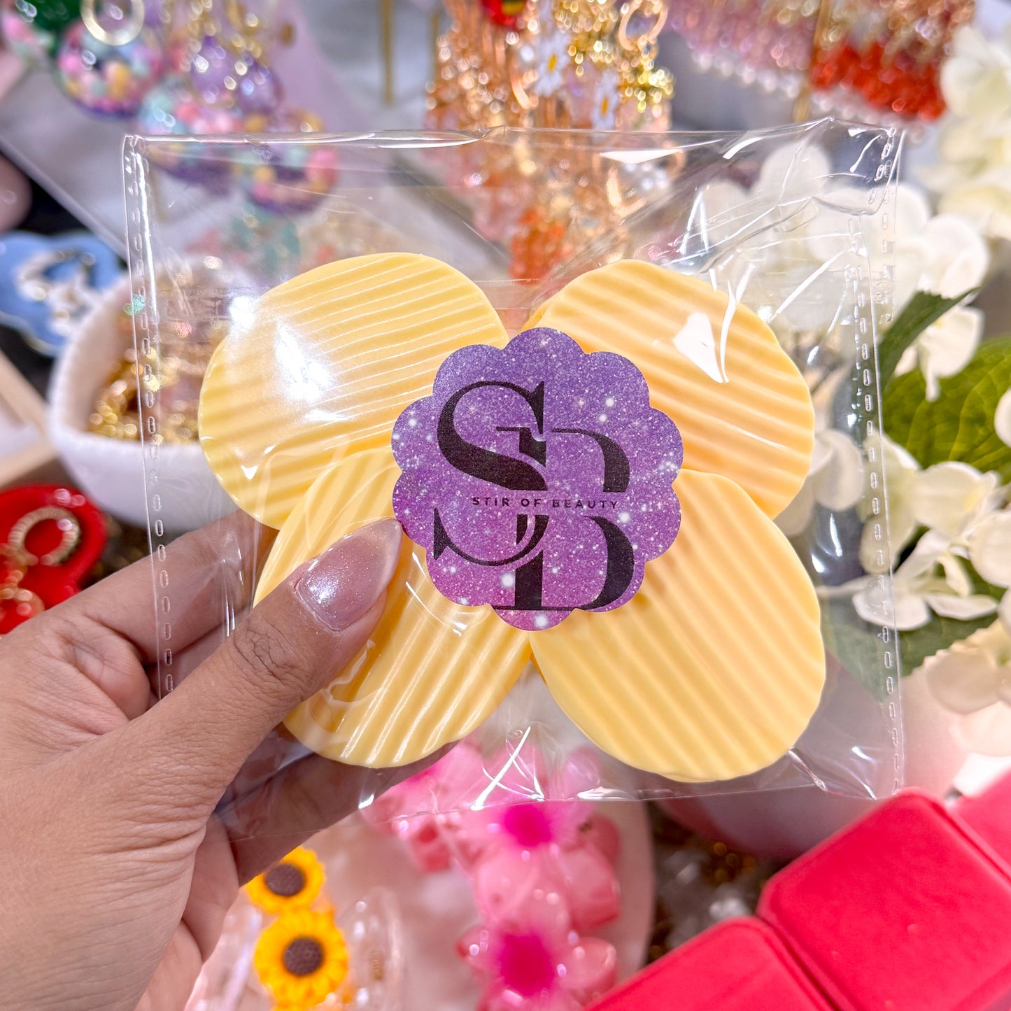 Yellow chip bag clip set from Stir of Beauty, held in its packaging, with a purple glitter logo sticker.

