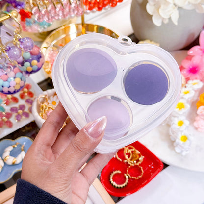Purple beauty blender set in a heart-shaped case with a clear lid.
