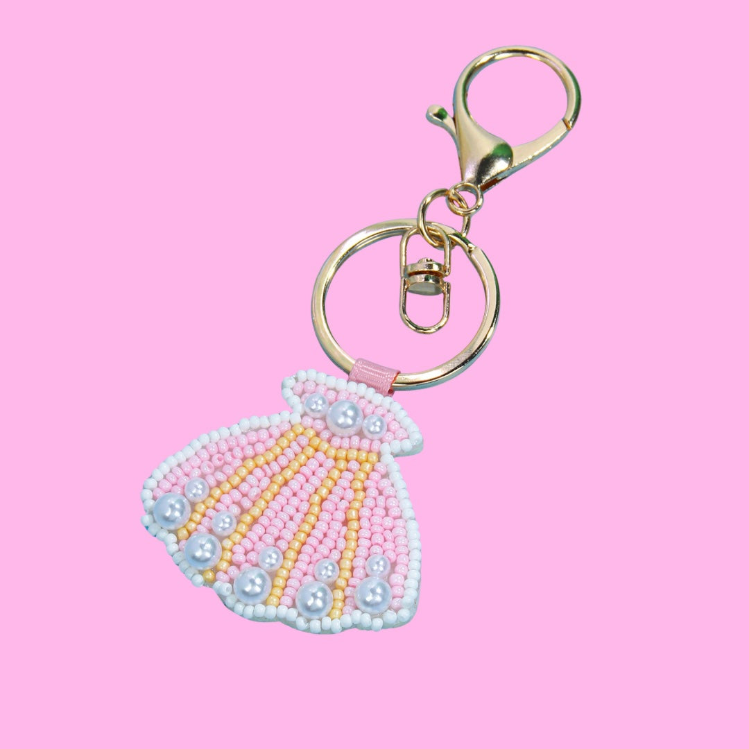Pink sea shell beaded bag charm with white, yellow beads, and pearls, attached to a gold-toned keyring and clasp.