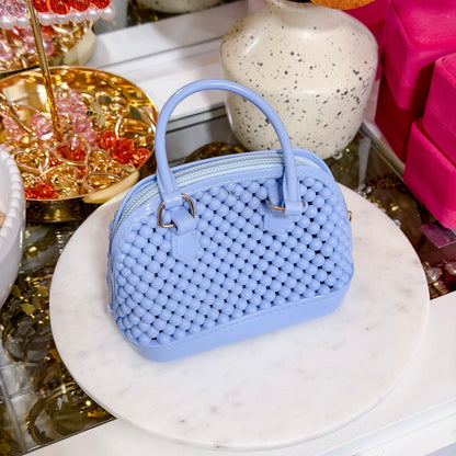 Light blue beaded dome bag from a vendor, displayed on a white marble surface.