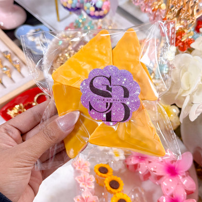 Yellow chip bag clips set by Stir Of Beauty, sealed in a clear plastic bag with a logo sticker.
