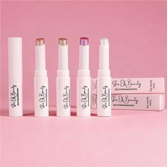 Five Stir Of Beauty Jelly Eyeshadow Sticks standing upright on a pink background, with shimmer shades visible and matching pink product boxes beside them.
