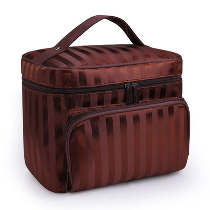 Brown makeup bag by Bella with vertical stripes, a top handle, and a front zippered pocket.